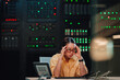 © Zamrznuti tonovi - Stressed it administrator feeling frustrated with a headache in a data center, experiencing burnout during network troubleshooting