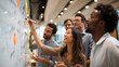 © kaki - Diverse team brainstorming and collaborating with markers on a whiteboard, conceptualizing ideas, perfect for business meetings, creative workshops and team building activities