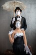 © Nomad_Soul - Mime couple posing together with a lace umbrella and a suitcase