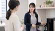© locomo - 日本人女性が休憩室で同僚と話す職場風景