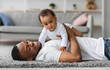 © Prostock-studio - Adorable Cute Baby Boy Lying On Father's Chest While They Relaxing At Home Together, Happy African American Dad Spending Time With His Infant Child, Enjoying Paternity Leave, Closeup