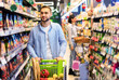© Prostock-studio - Everyday Shopping. Portrait Of Young Bearded Guy Walking With Trolley Cart Between The Aisles In Wholesale Store. Casual Man Buying Healthy Food In Shop, Looking At Shelves, Blurred Background