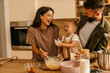 © La Famiglia - Happy family baking together in kitchen, making cookies