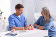 © New Africa - Doctor consulting woman regarding dental implantation at desk in clinic