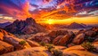 © rozan - A vibrant sunset casts dramatic colors across a rocky, mountainous desert landscape.