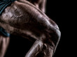 © IndyWingman - Extreme close up, big leg muslce of bodybuilder very strong and lean muscle mass , black background ,sport image.