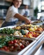 © Evgeniia - Fresh vegetables displayed in stainless steel cafeteria buffet trays ready for school lunch service. Healthy nutrition, balanced meals and institutional food service concept