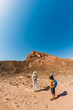 © zhukovvvlad - A mother and child on a hike. A boy with a map and a backpack walks next to his mother. Family trekking. Timna National Park. The child is actively spending time.