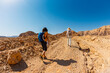 © zhukovvvlad - A mother and child on a hike. A boy with a map and a backpack walks next to his mother. Family trekking. Timna National Park. The child is actively spending time.