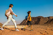 © zhukovvvlad - A mother and child on a hike. A boy with a map and a backpack walks next to his mother. Family trekking. Timna National Park. The child is actively spending time.