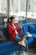© Stock 4 You - Young latin or indian female student studying on digital tablet technology in headphones for online learning. Vertical portrait of woman browsing educational content on device in campus or office.
