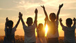 © taa - Group of diverse children with arms raised in celebration against a golden sunset, representing joy and togetherness