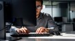 © Sri - Businessman with glasses looking intensely at a computer monitor while typing on a keyboard in a dark office, symbolizing data analysis, cyber security, coding, and focus.