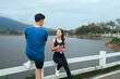 © PaeGAG - Asian couple relaxing by lake after exercise