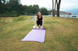 © PaeGAG - Young woman rolling up yoga mat after outdoor exercise
