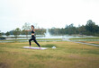 © PaeGAG - Young woman practicing warrior pose yoga in outdoor park
