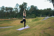 © PaeGAG - Woman practicing yoga tree pose for balance outdoors