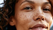 © Newleks - Close up portrait beaming young woman displaying natural beauty with a genuine smile and captivating eyes, showing authentic freckled skin and healthy curly hair