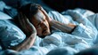© Marta P. (Milacroft) - Person suffering from tinnitus and insomnia, unable to sleep, covering head with blanket due to noise and discomfort at night