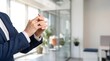 © Abdul - Businessperson in blue suit standing confidently in modern office with hands together in front of them showing a sense of professionalism and leadership