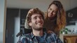© ELENA AI - A happy disabled guy looks up laughing while his loving partner gently touches his curly hair in a cozy kitchen. Concept of deep affection and romantic couple support.
