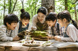 © GIHUN KIM - Teacher and children examining nature with a magnifying glass in the forest