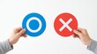 © Abdul - Two hands holding circular signs featuring a blue correct circle symbol and a red incorrect cross symbol isolated against a plain clean white studio background