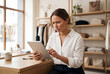 © Meow Creations - Frustrated female boutique owner looking at digital tablet screen in clothing store