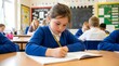 © gereh - Young student writing in notebook at classroom desk learning and studying
