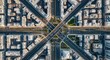 © soem - An aerial photograph showcases a complex urban intersection at sunrise. Tall buildings surround the crossroads, creating a grid-like pattern.