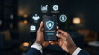 © dody - Businessman hands holding smartphone displaying secure payment system with holographic business icons in office