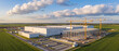 © itlada - Aerial view of industrial data center construction site with yellow tower cranes, modern concrete buildings, and parking lots under a blue sky for infrastructure development concepts