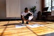 © Rawpixel.com - Man organizing papers on a wooden floor in a sunlit room.