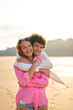© Alvaro Lavin/Stocksy - Happy couple hugging on beach during vacation sunset