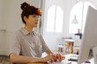 © BONNINSTUDIO/Stocksy - Redhead woman working at computer in bright office space