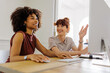 © BONNINSTUDIO/Stocksy - Professionals collaborating and smiling in office setting