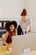 © BONNINSTUDIO/Stocksy - Colleagues collaborating on computer at modern office space