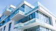 © Momin Photo Gallery - Elegent photo of Modern luxury apartment building exterior with glass balconies against a clear blue sky. Ideal for architectural design and real estate investment concepts.