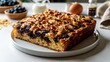 © Jam - Golden keto blueberry almond cake on a white plate with fresh ingredients in a bright kitchen