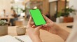 © Erlanggandi - Woman Holding a Smartphone with a Blank Green Screen Mockup for Digital Interface Display and Mobile Application Design