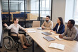 © Nazia - Business meeting photo with wheelchair professional leading diverse office team