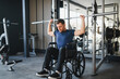 © Serhii - Man with disability lifting weights in wheelchair at gym for rehabilitation