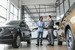© Serhii - Portrait of male client talking to professional car dealer in dealership.