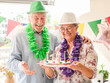 © luciano - Adult couple, celebrating a significant anniversary or birthday milestone, enjoying a festive party atmosphere with colorful decorations and a sweet treat