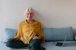 © Anna Berkut/Stocksy - entrepreneur senior woman with laptop, portrait looking at camera