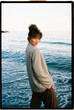 © Tania Cervian/Stocksy - Woman looking back posing by the sea