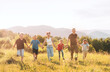 © Soloviova Liudmyla - Happy group of children running holding hands through sunny summer mountain meadow during joyful outdoor activity enjoying beautiful golden hour light, freedom and active lifestyle together