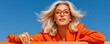 © Georgii - Confident blonde woman in orange blazer and glasses looking upward against a clear blue sky