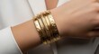 © Henderson - Woman wearing beautiful gold bangles with floral patterns on her wrist
