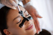 © Home-stock - Closeup of relaxed woman receiving charcoal face mask on T-zone while esthetician performing luxury skincare procedure in beauty center
